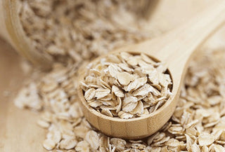 Pile of oats with a wooden spoon