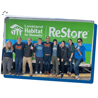 Bobo's team members standing behind a Loveland Habitat for Humanity billboard
